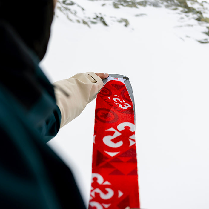 person holding a ski with a minimist climbing skin