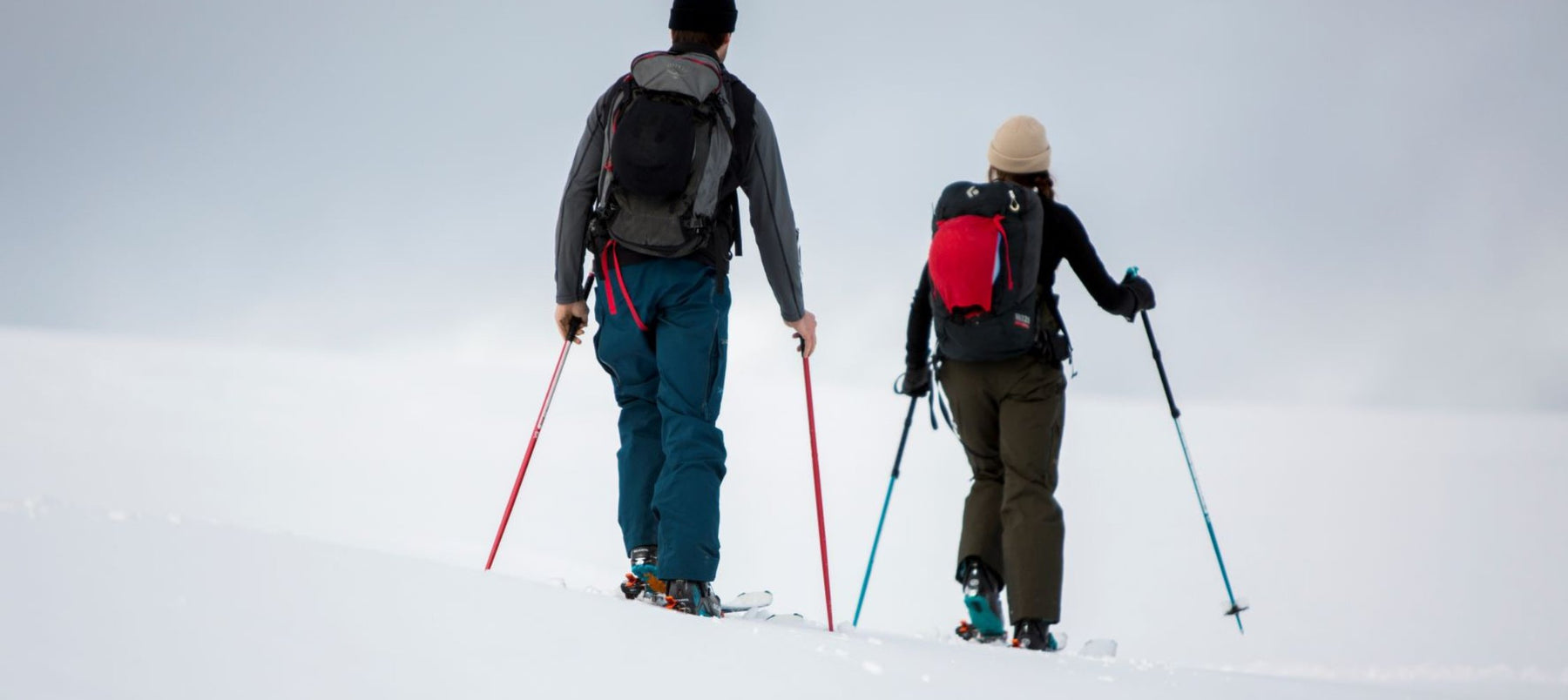 two people ski touring holding poles