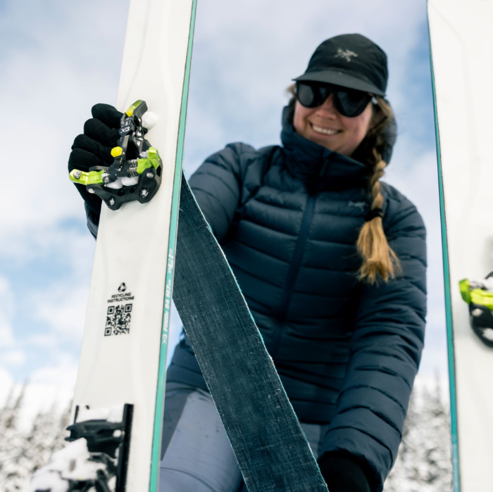 woman smiling while putting climing skins on her skis with ZED bindings