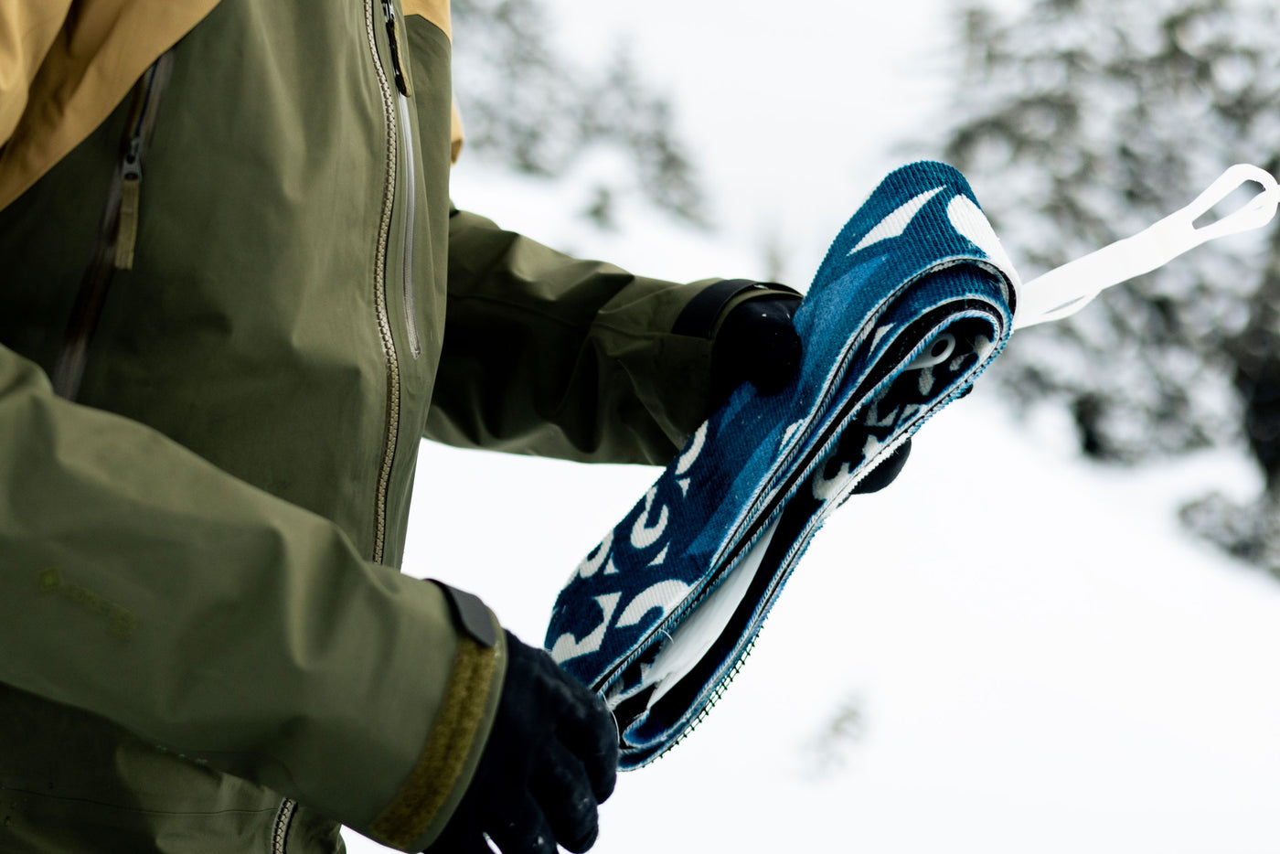 person holding folded grip climbing skins